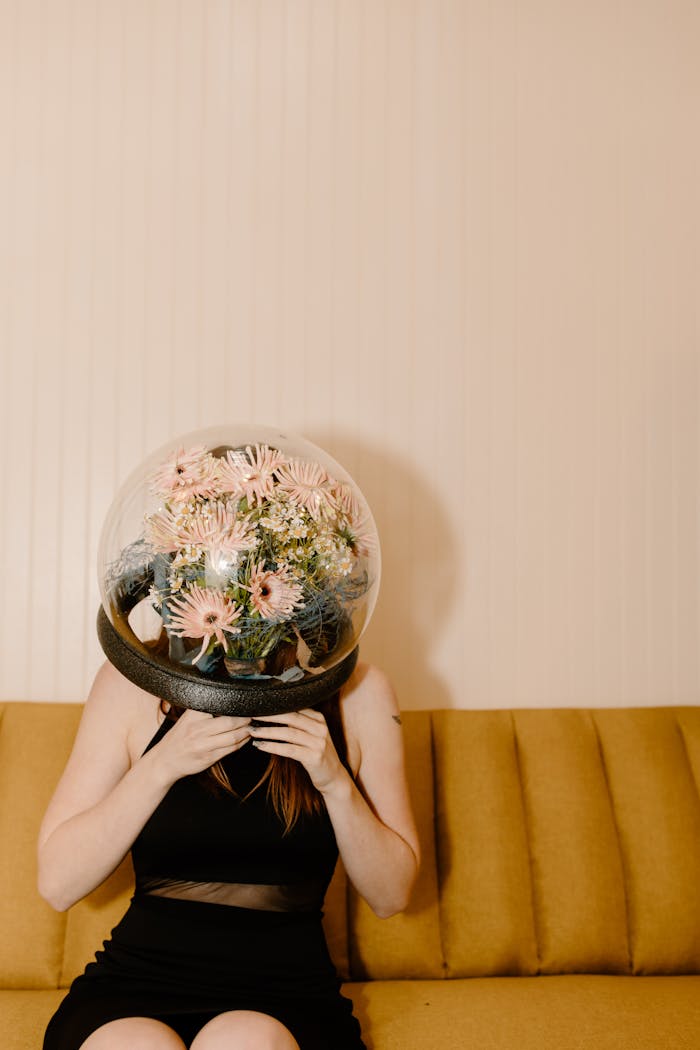 A woman in a black dress wears a flower-filled dome, blending nature and futurism.
