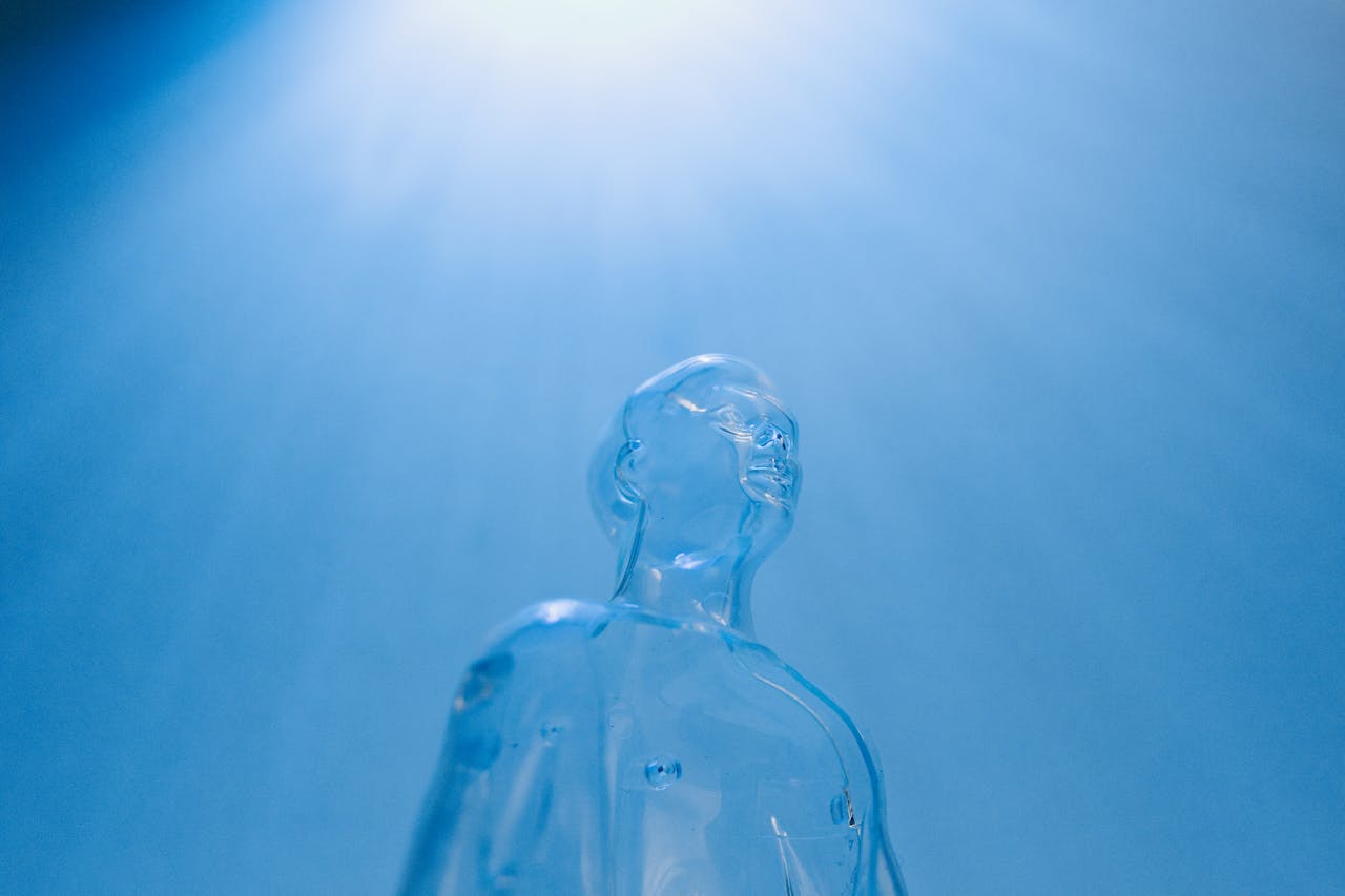 Transparent figure against a blue sky, symbolizing futuristic concepts and technology.